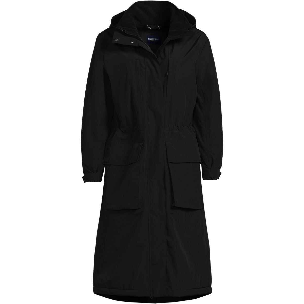 Woman over 50 wearing a long black insulated coat below the knee over a fall capsule outfit.