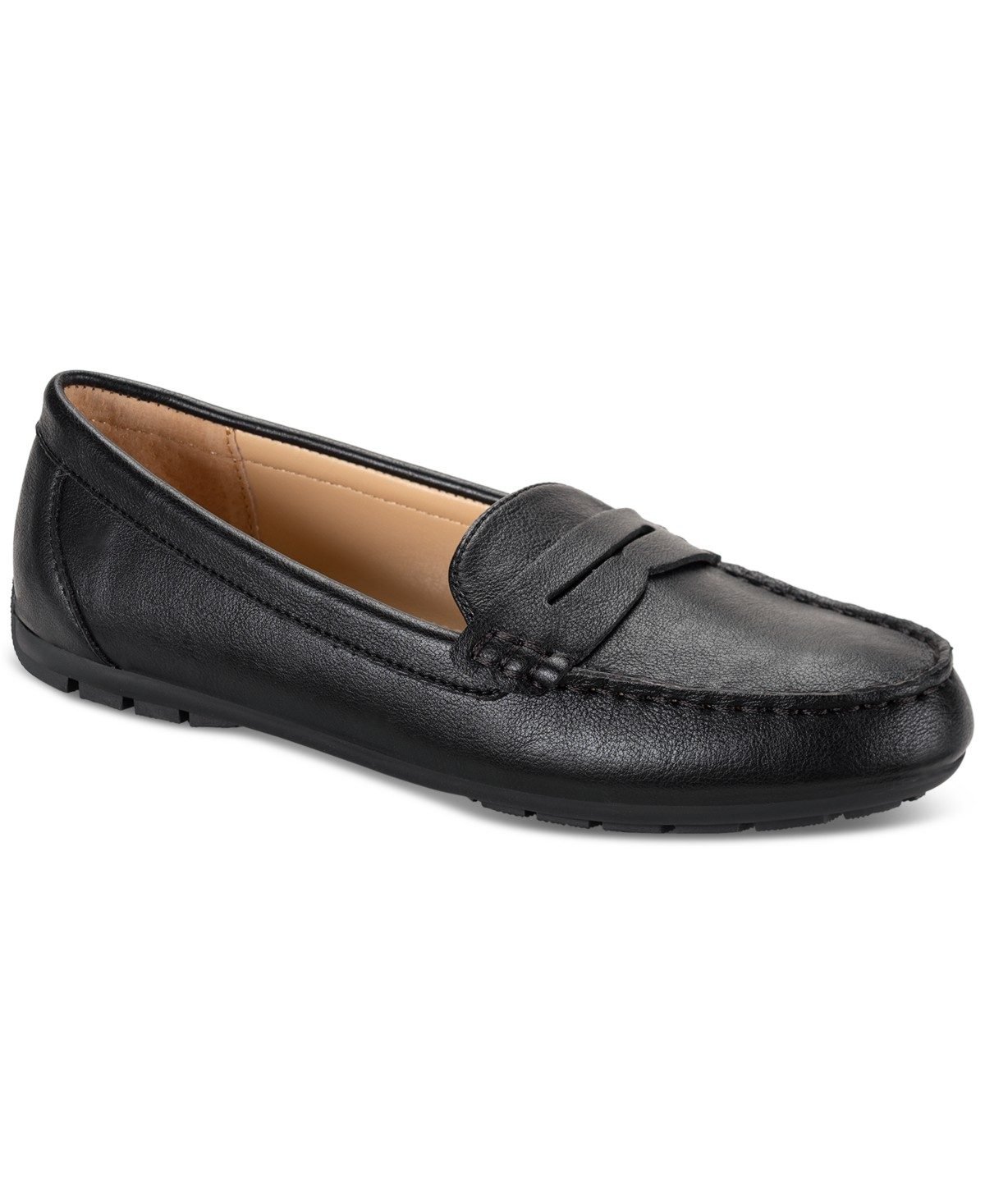 Woman over 50 wearing classic black penny loafers with white jeans and a navy cardigan.