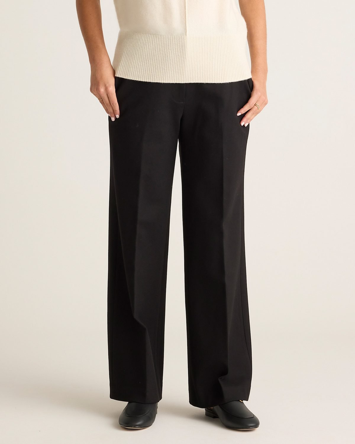 Woman over 50 wearing black pull on ponte trousers with a flat front, a polished capsule staple.