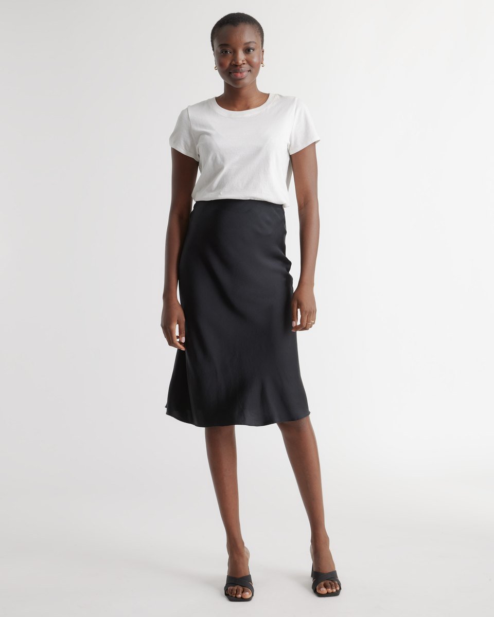 Black washable silk bias-cut midi skirt from Quince with a hidden elastic waist, styled with a white tee
