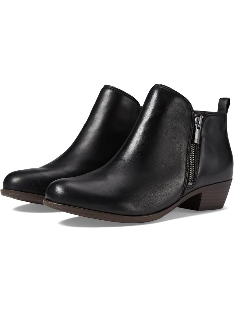 Black leather ankle bootie with dual side zips and a low stacked heel, a classic fall boot for women over 50.