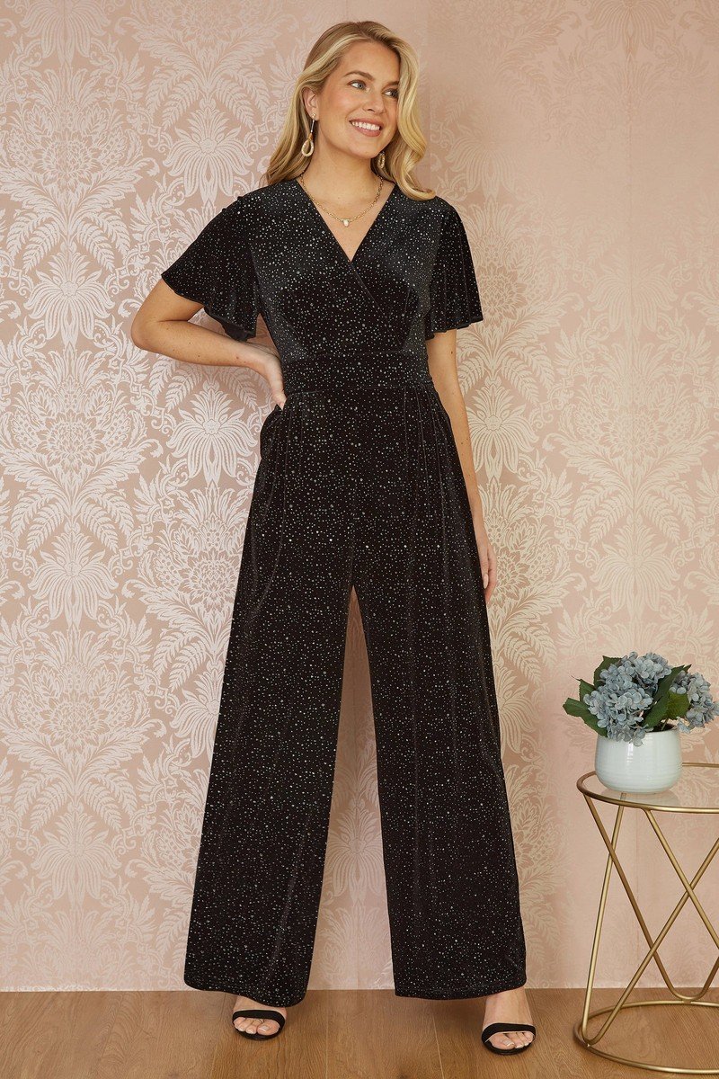 Black velvet jumpsuit with fine silver sparkle, a wrap neckline, angel sleeves and wide legs.