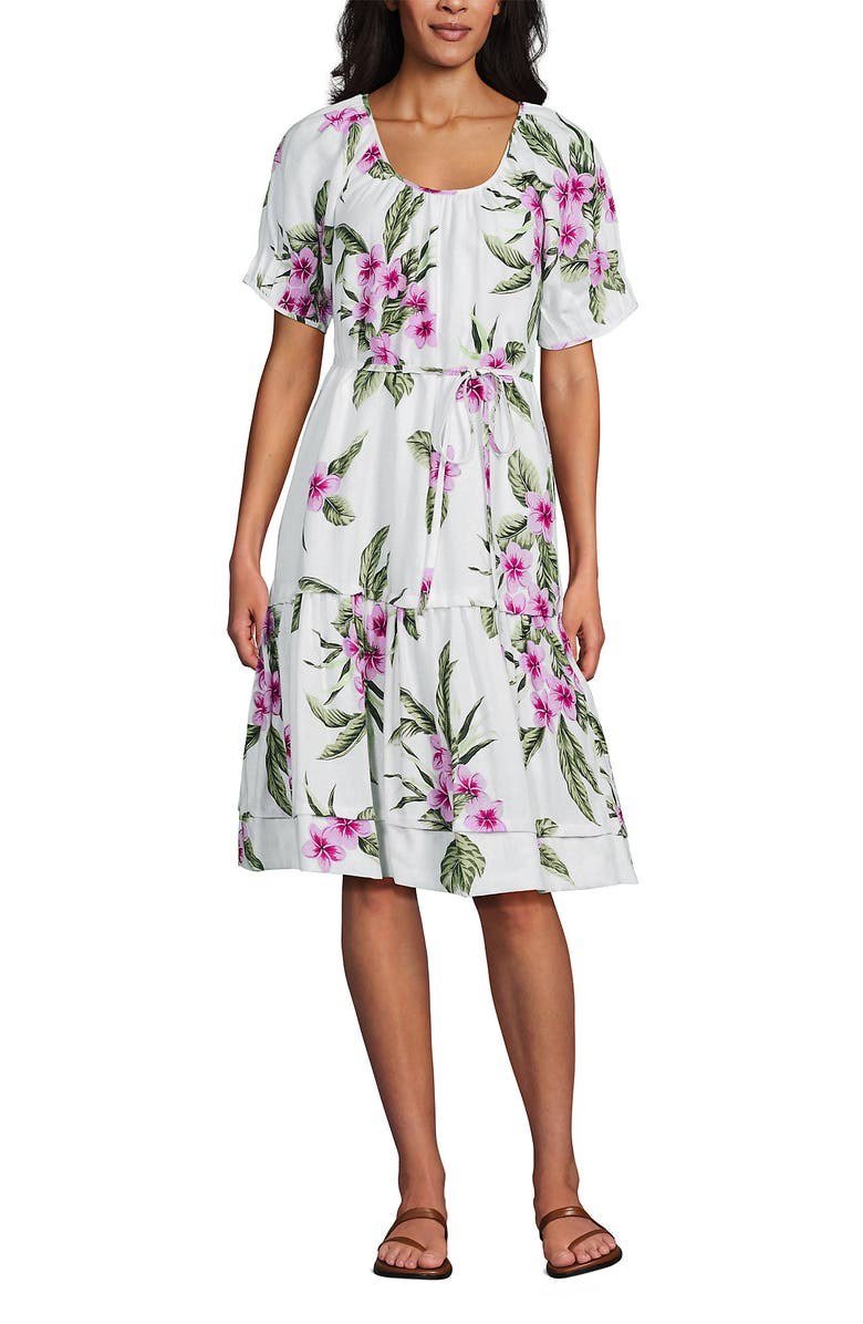 White knee length dress with a pink floral print, scoop neck, puff sleeves and a drawstring waist.