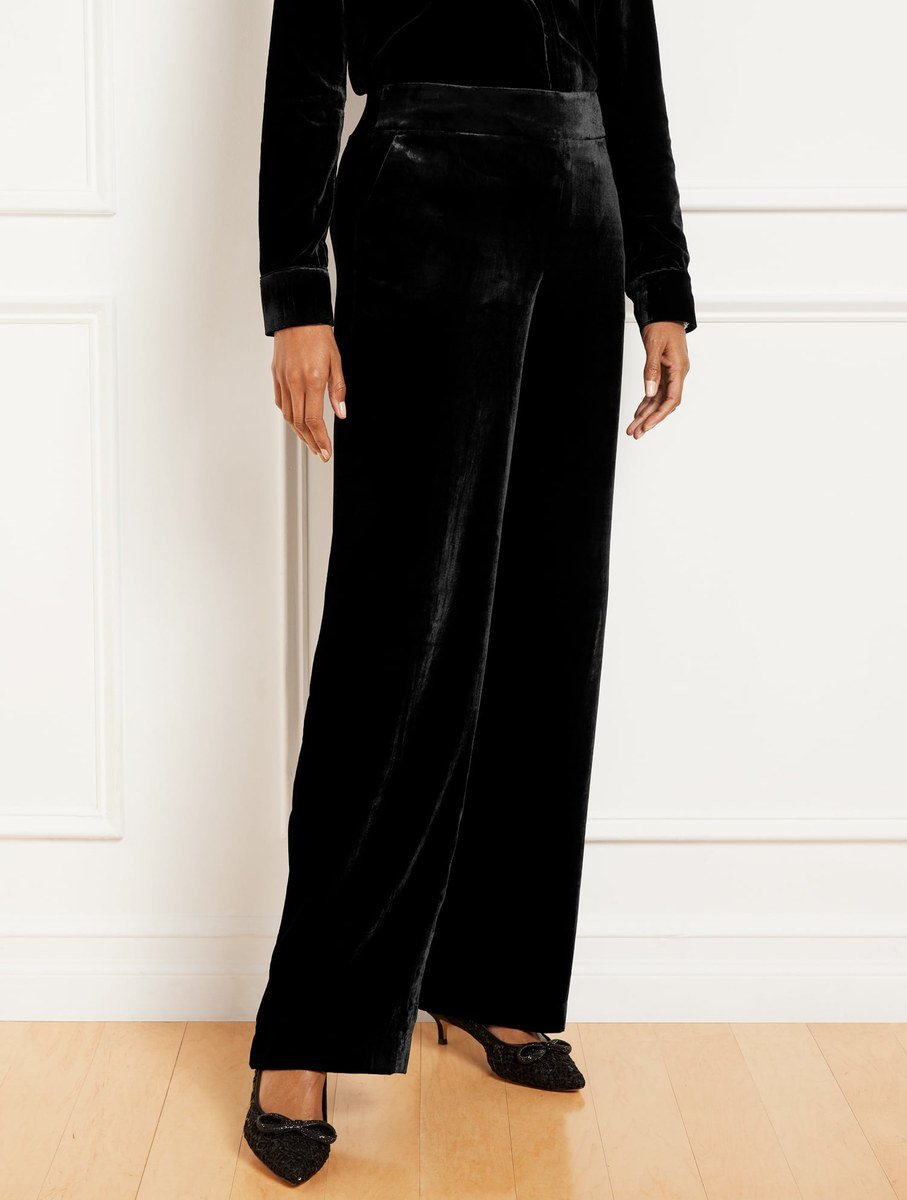 Black velvet wide leg pants with a flat front and side zip, worn with heels for an evening outfit over 50.