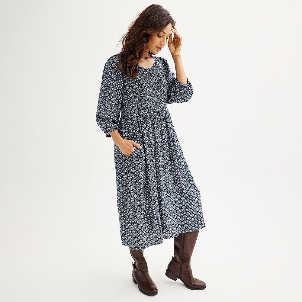 Navy midi dress with a small white floral print, smocked bodice, three quarter sleeves and pockets.