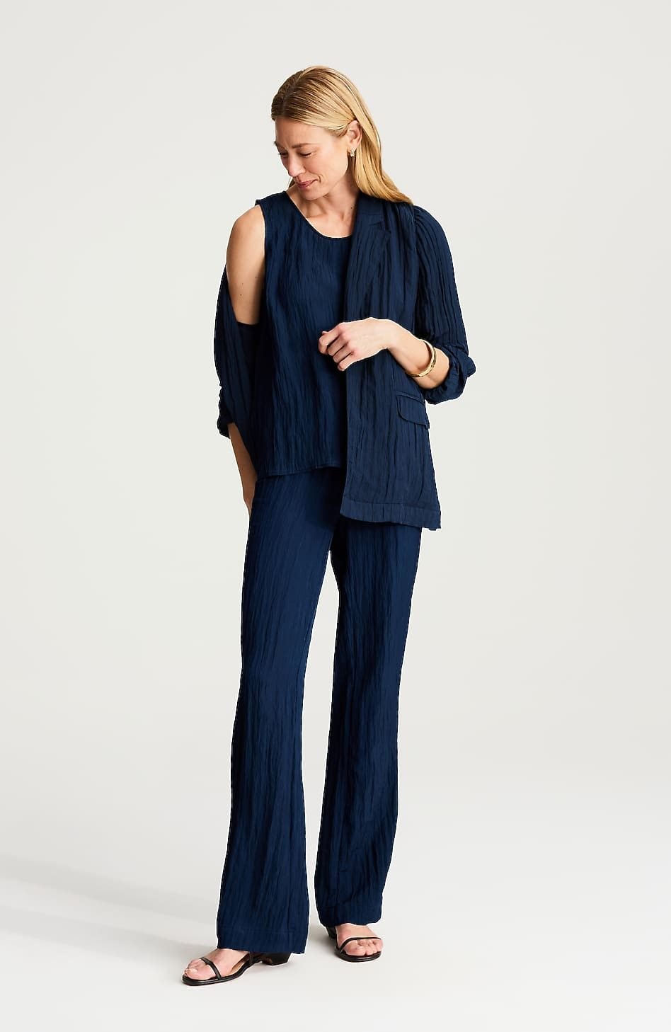 Woman over 50 wearing crinkled full leg pull on pants with a fitted tee and denim jacket, a casual weekend outfit.