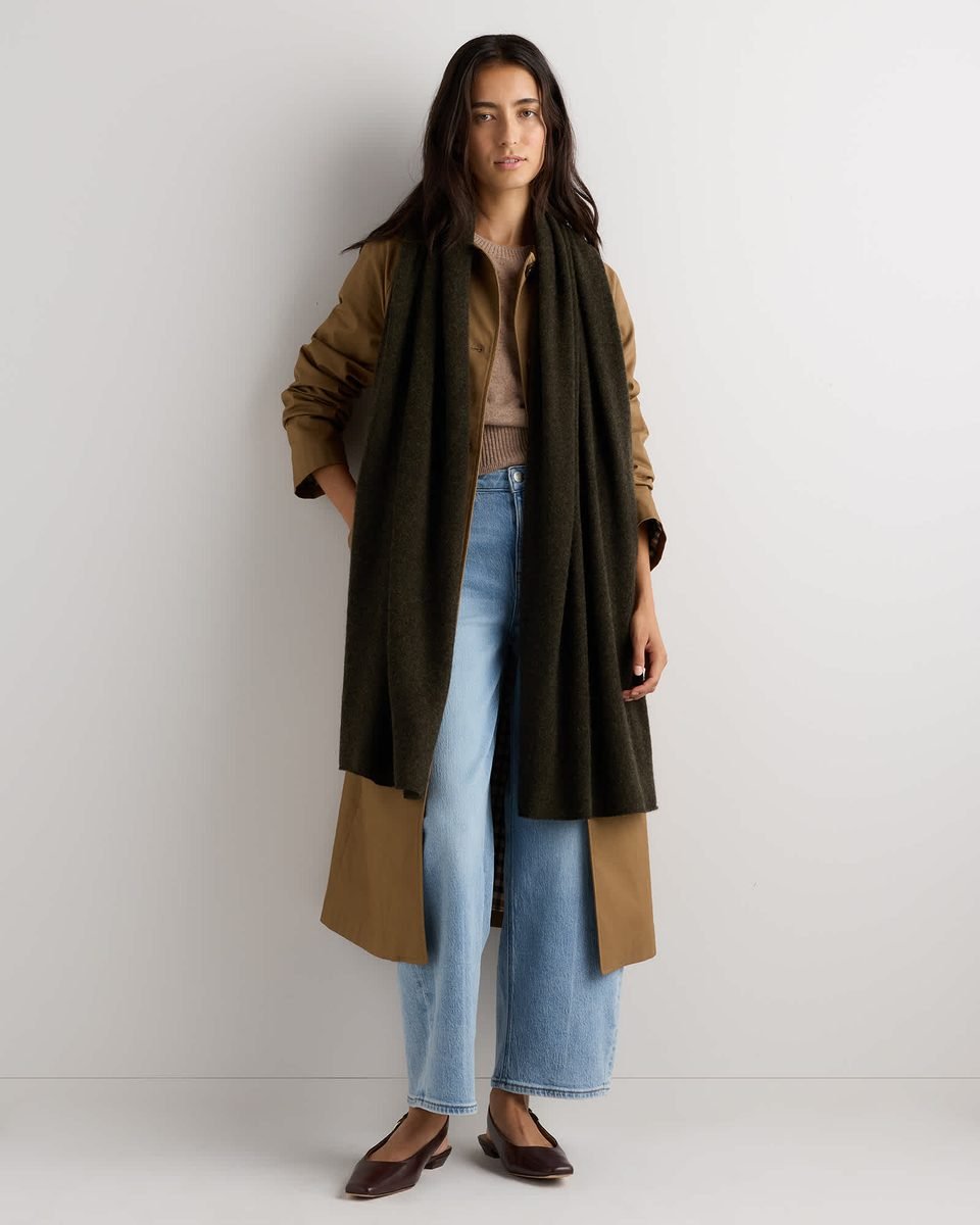 Mongolian cashmere wrap in a deep olive shade, worn long over the shoulders as an evening layer.