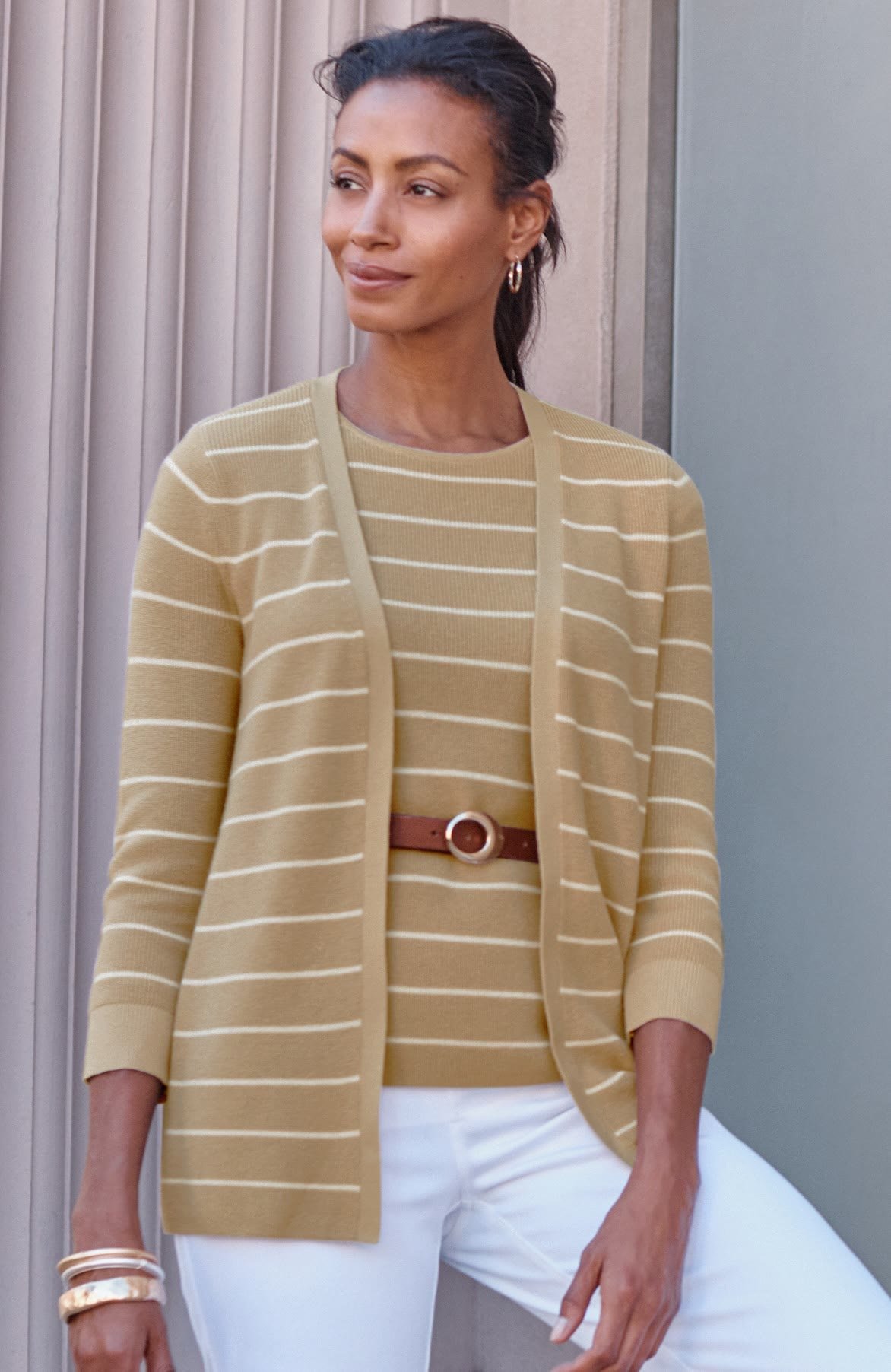 Woman over 50 wearing a long open ribbed cardigan over slim pants, a tummy flattering layered outfit.