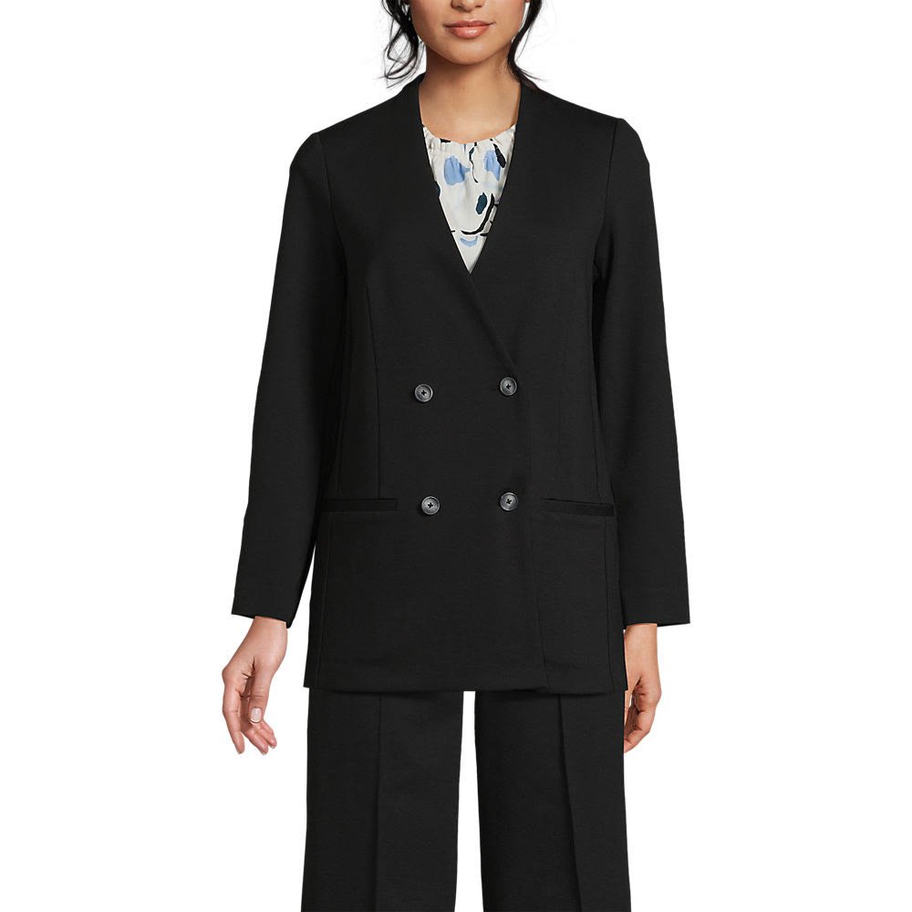 Woman over 50 wearing a ponte knit blazer over dark high rise straight leg jeans, a smart casual Thanksgiving guest outfit.