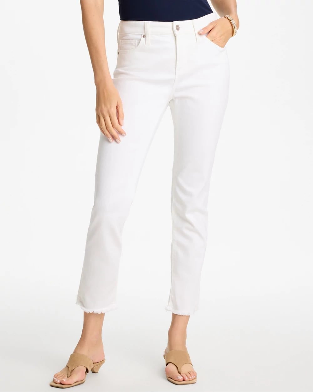 Woman over 50 wearing alabaster ankle jeans with an indigo denim jacket with a corduroy collar.